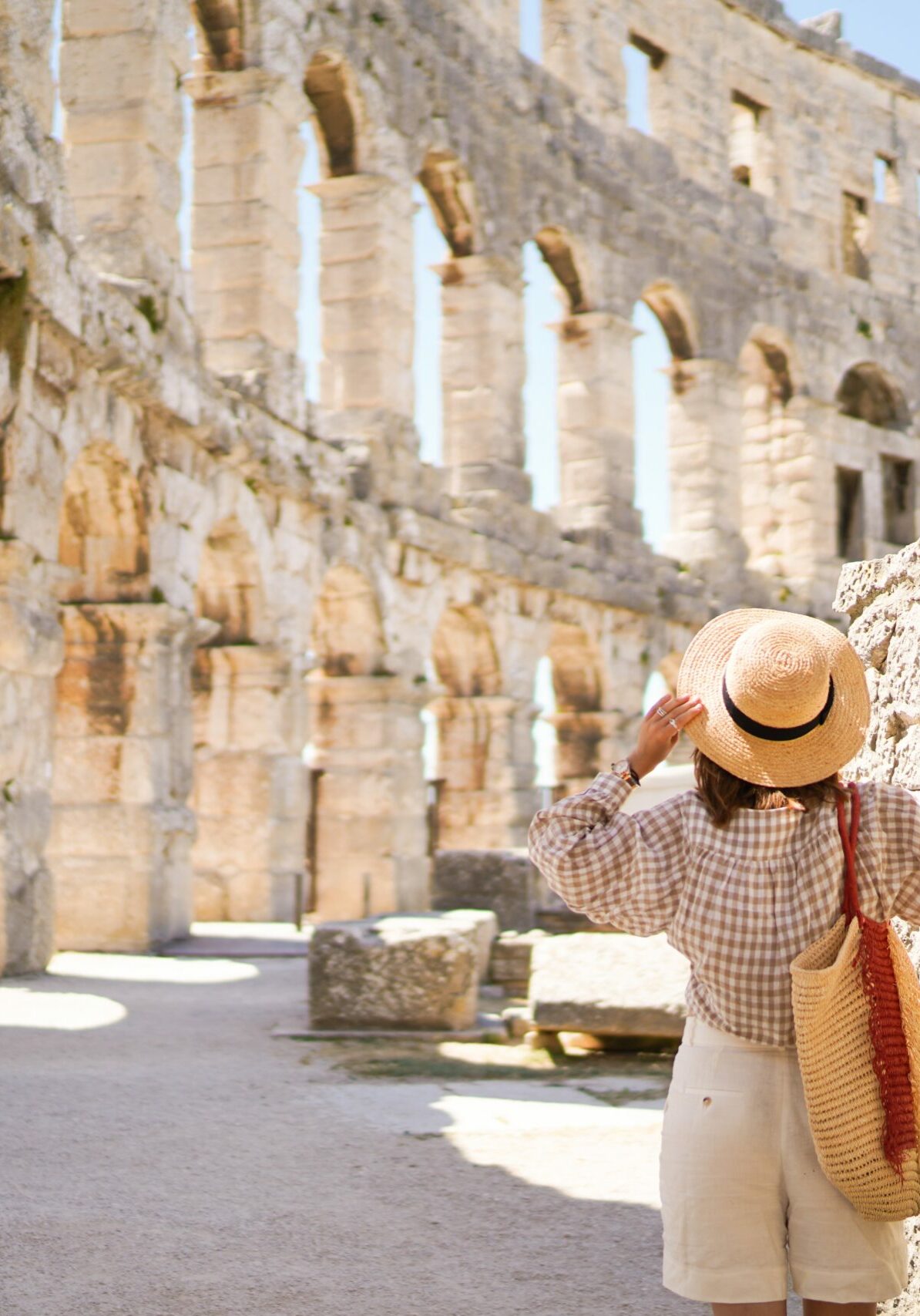 Woman,In,Hat,Stands,And,Looking,On,Coliseum,In,Pula Woman,In,Hat,Stands,And,Looking,On,Coliseum,In,Pula